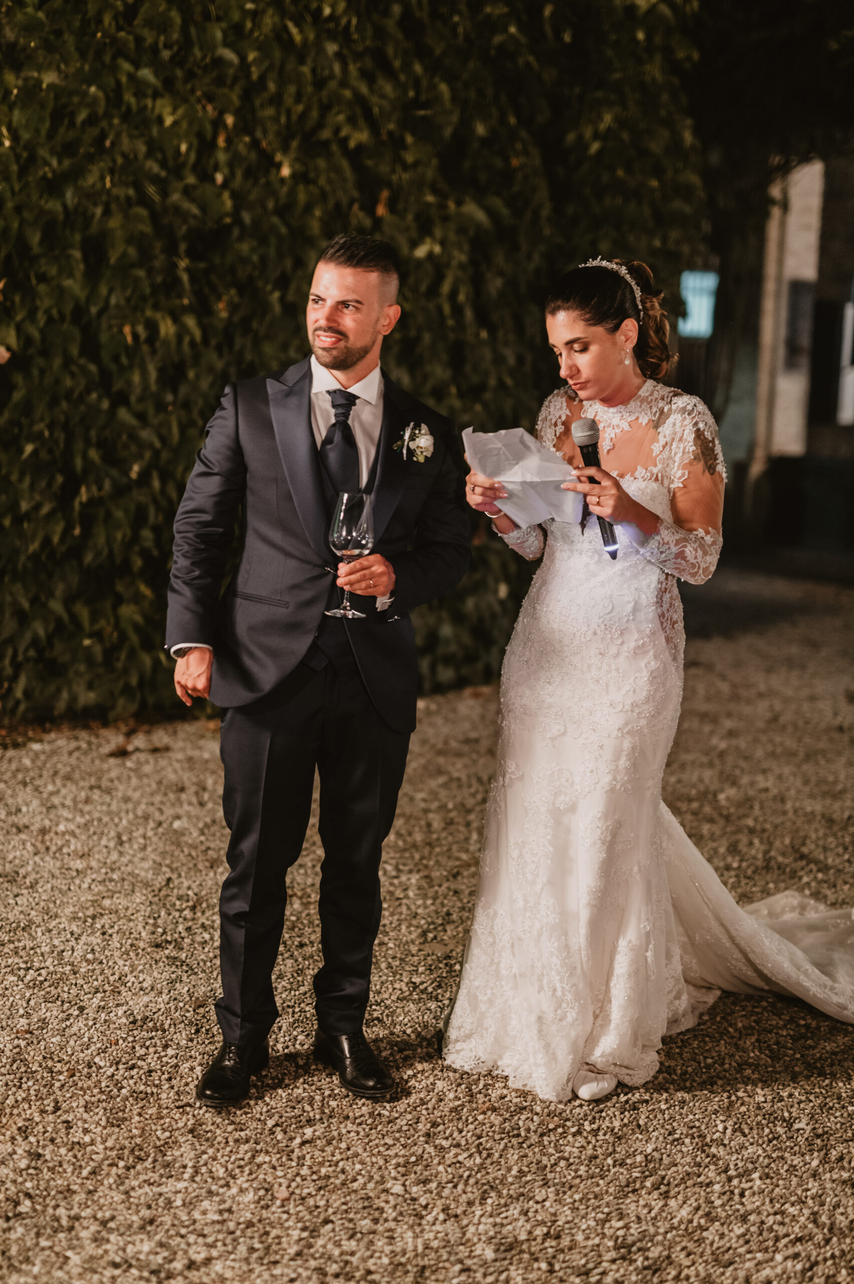 Gli sposi durante il discorso al ricevimento, la sposa legge al microfono