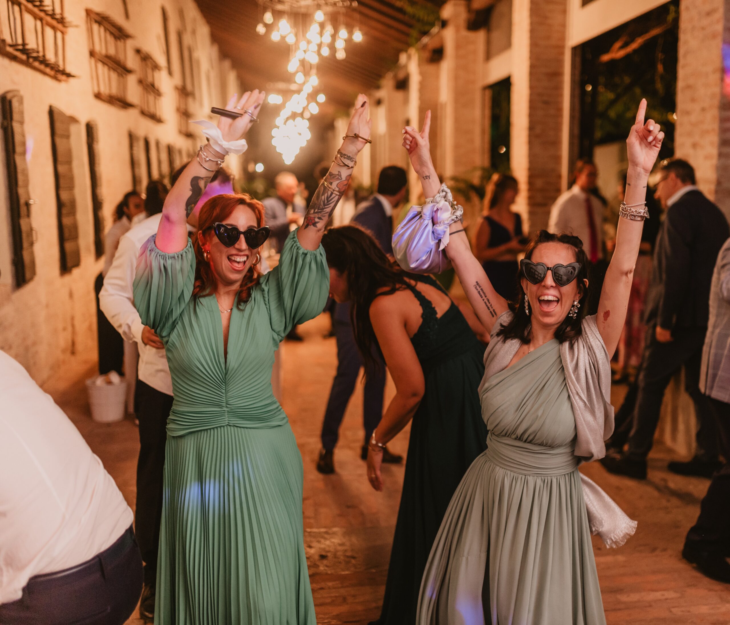 Invitate che ballano con occhiali a cuore durante la festa di matrimonio