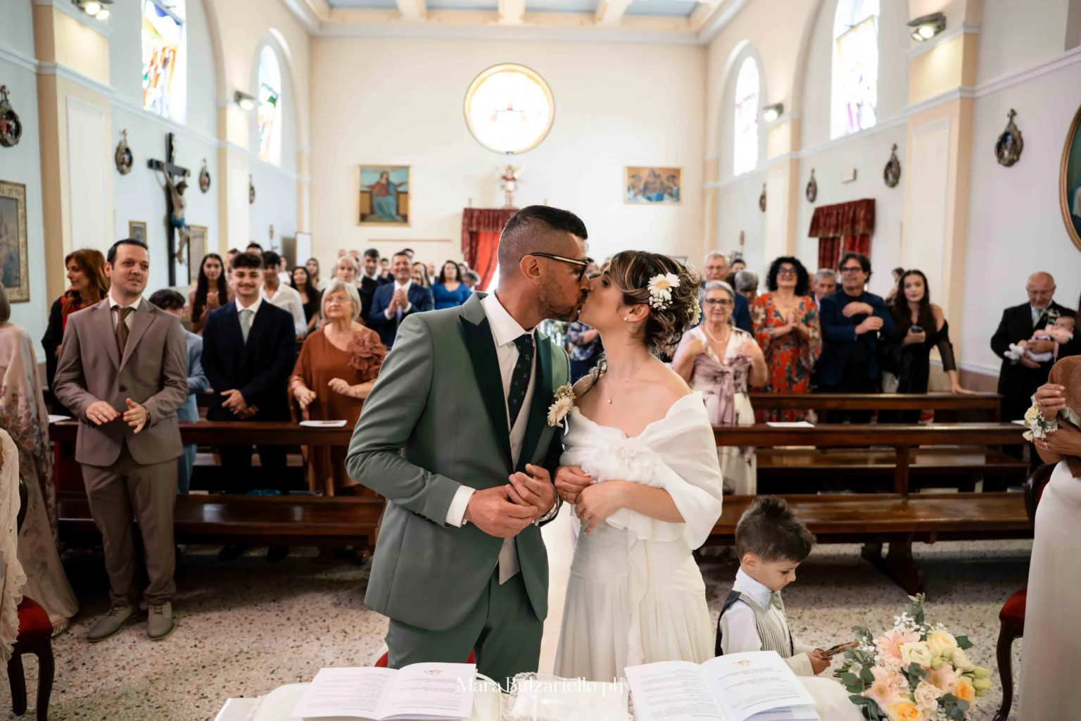 Fotografia del bacio degli sposi durante la cerimonia in chiesa