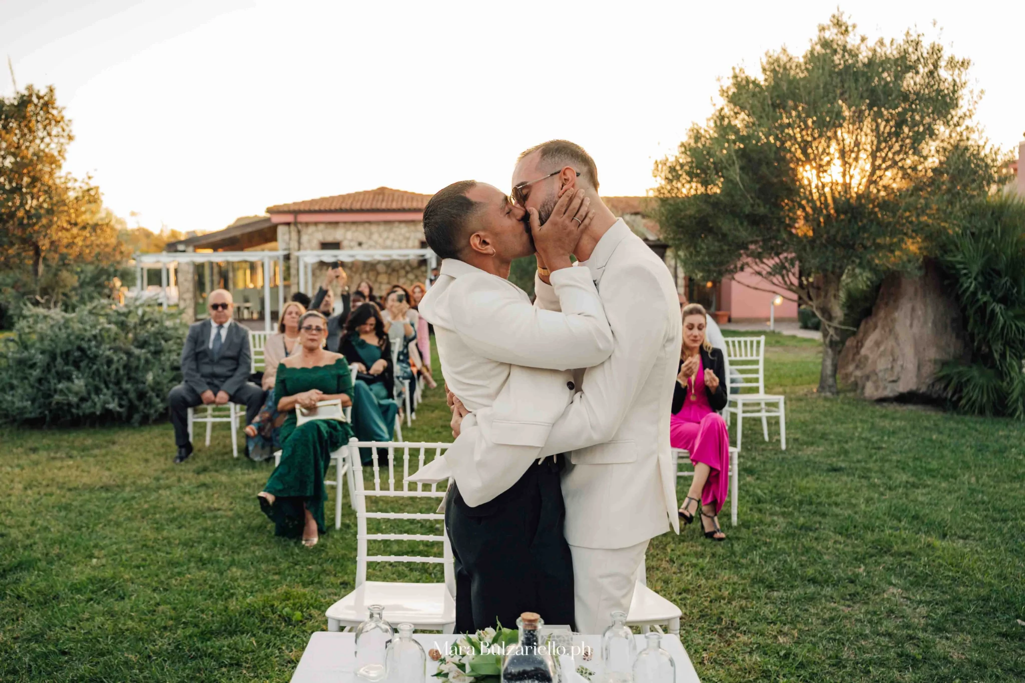 Due sposi si scambiano un bacio durante la cerimonia